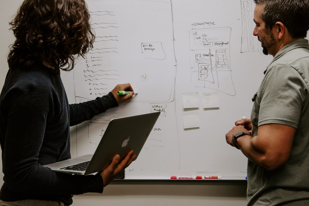 Two men in front of whiteboard