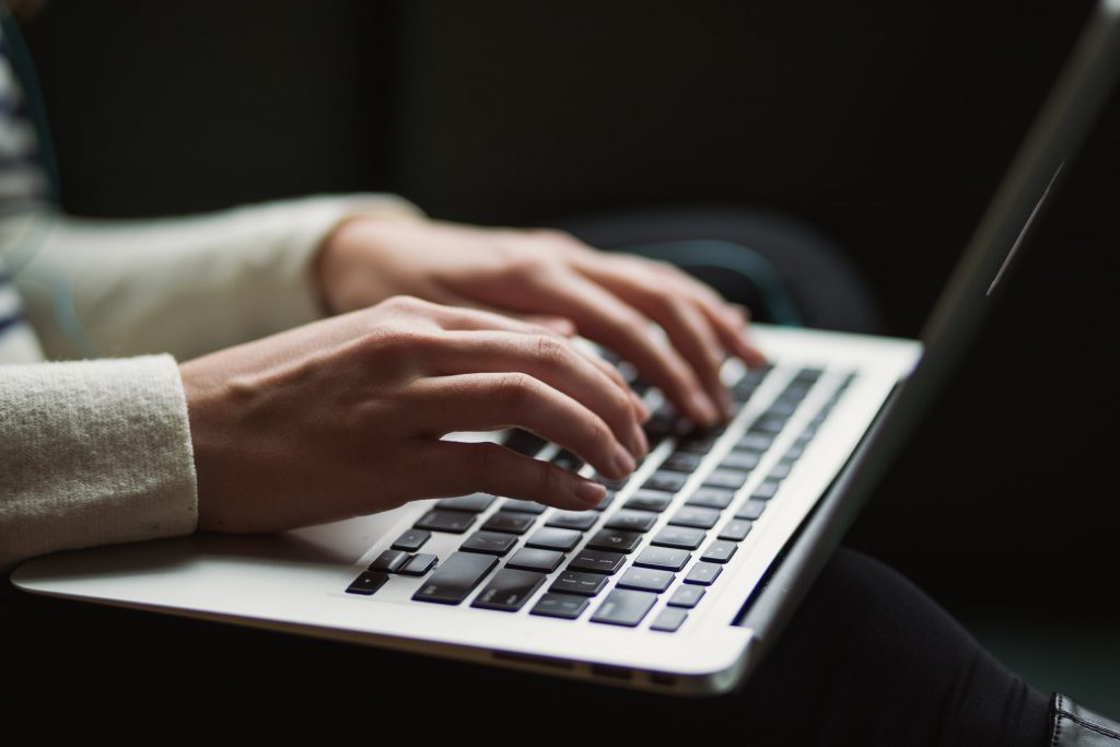 Person typing with laptop in lap