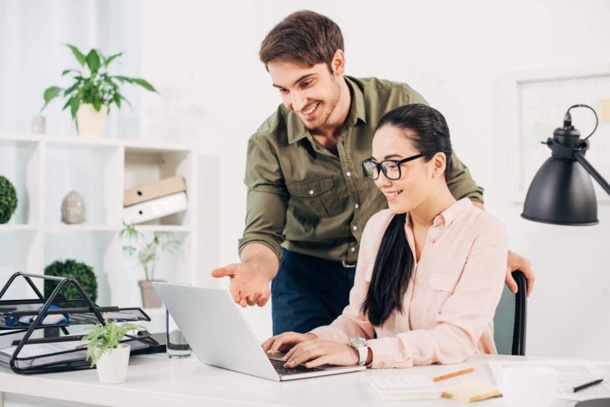 Two people smiling at laptop