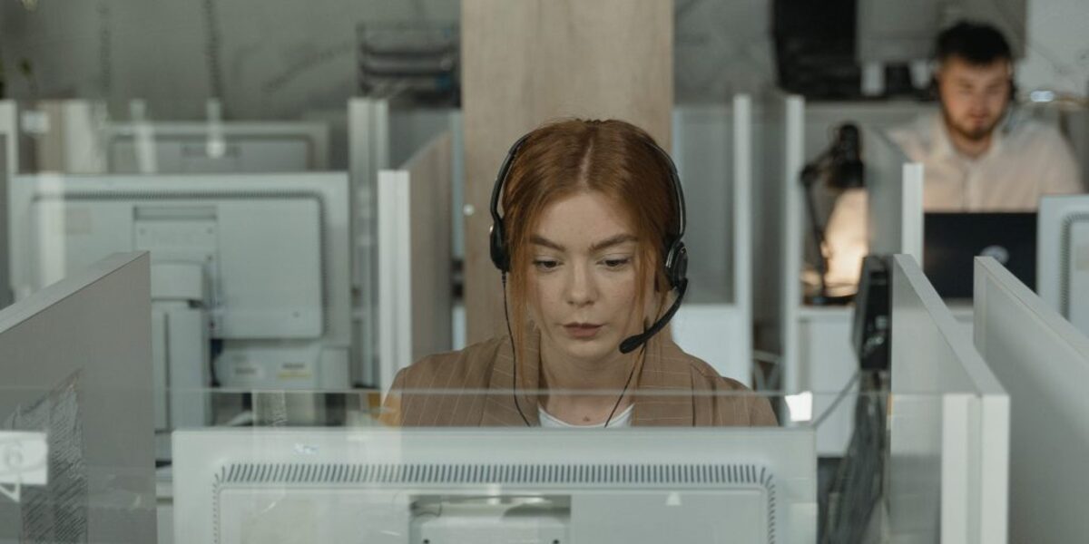 Woman in brown shirt wearing black earbuds