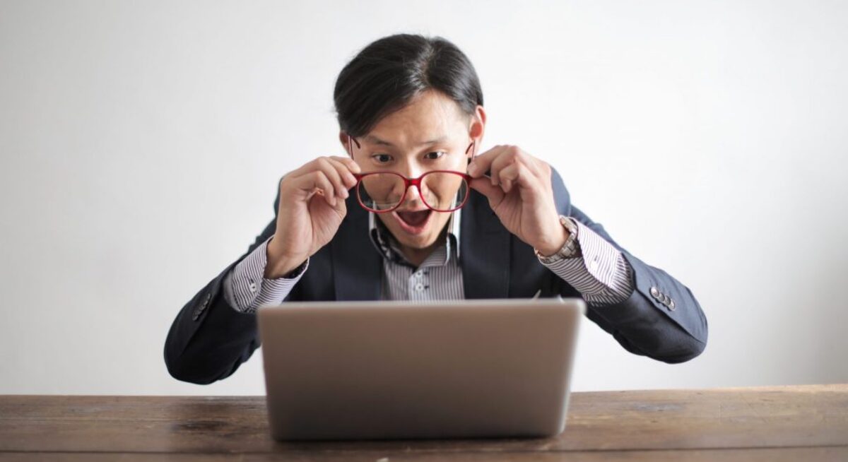 Amazed formal male looking at laptop screen