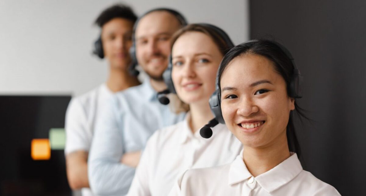 Call center agents smiling while looking at camera