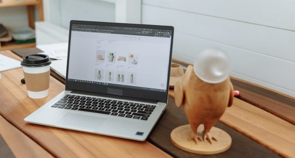 Laptop on a wooden table with the design business website on the screen