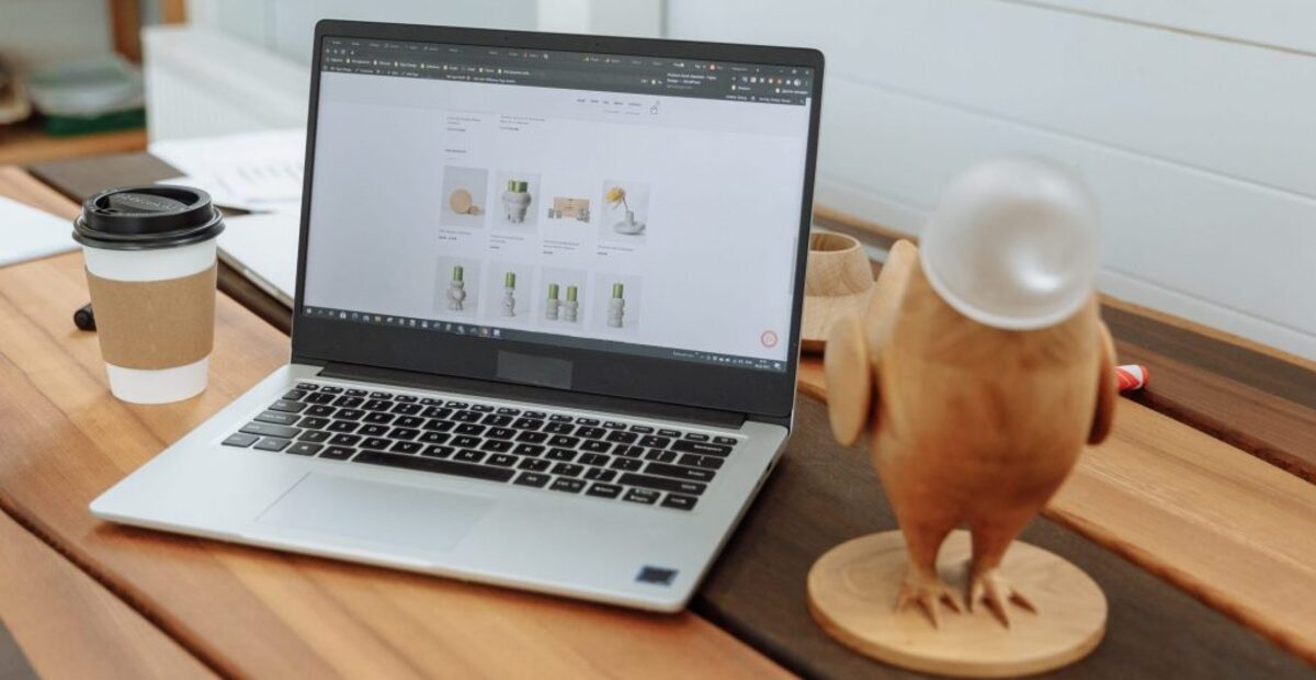 Laptop on a wooden table with the design business website on the screen