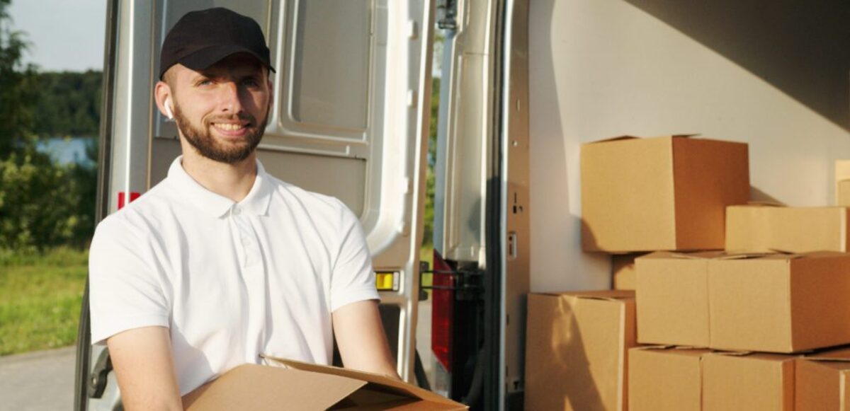 Man smiling while holding a box