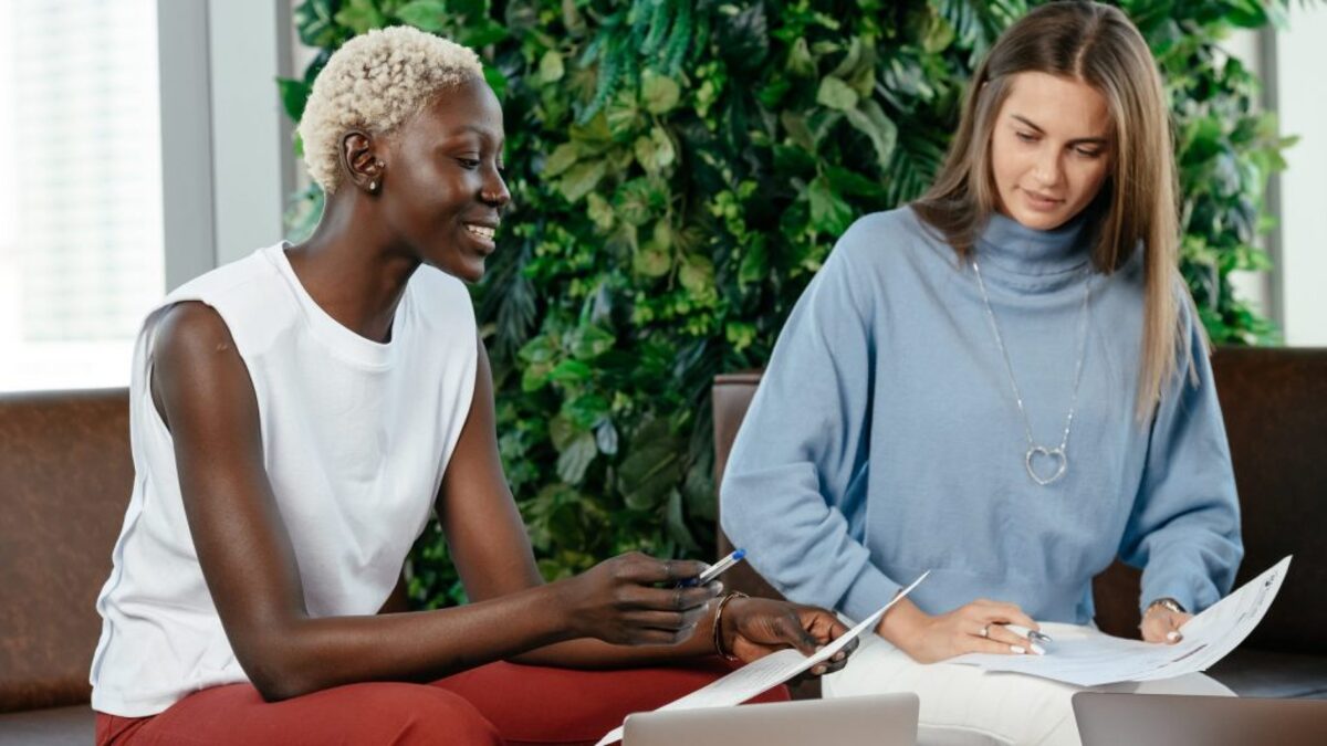 Multiracial colleagues checking important report on papers