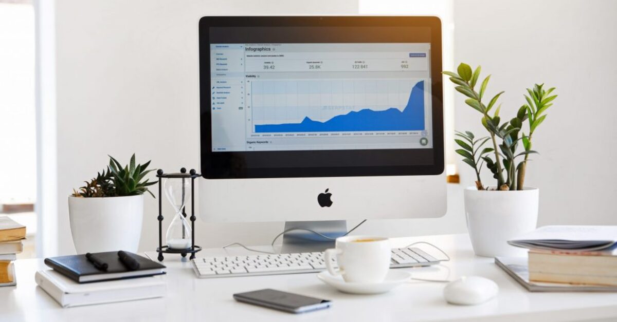 Silver imac displaying line graph placed on desk