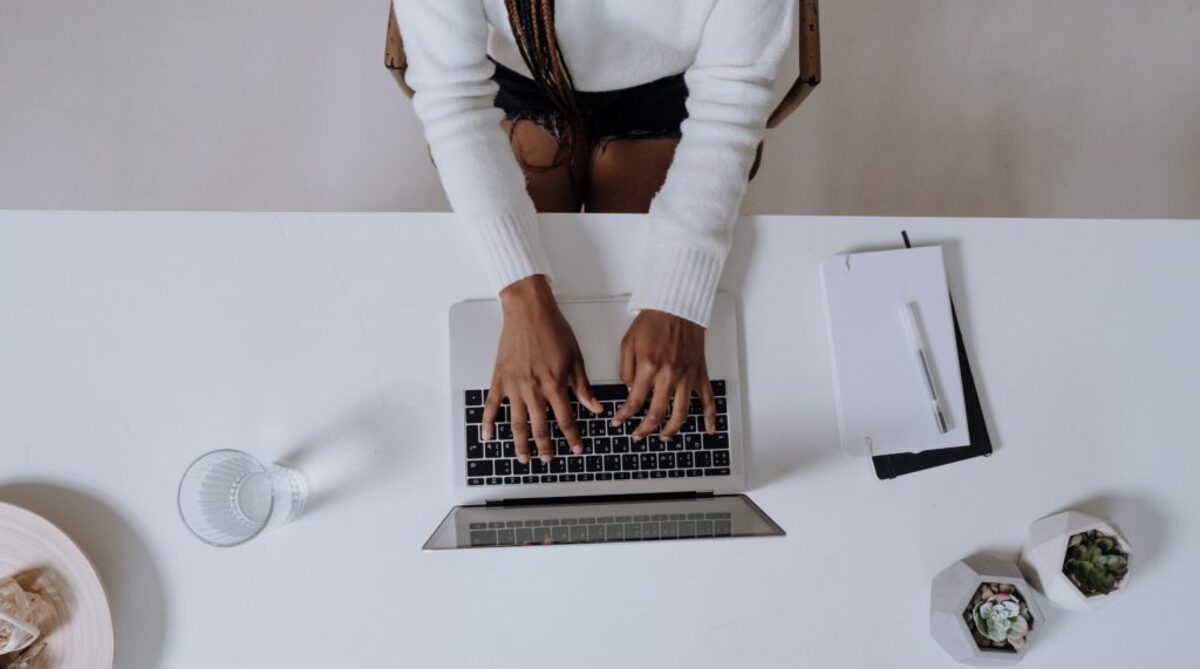 Woman in white long sleeve shirt using macbook pro