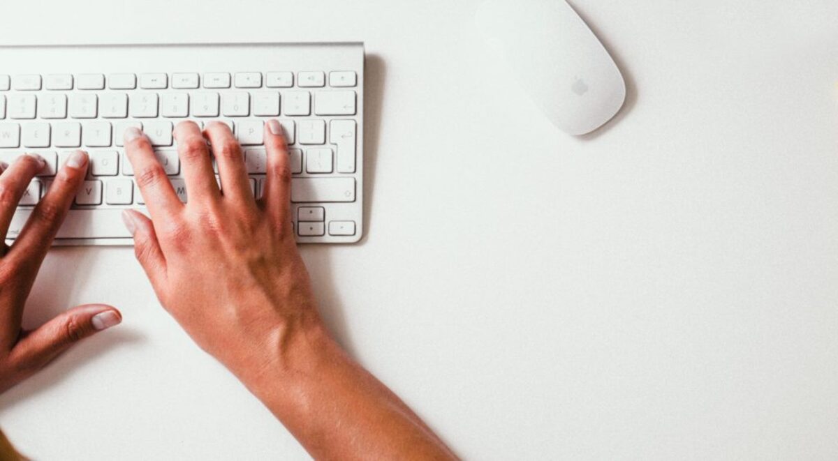 Person holding apple keyboard