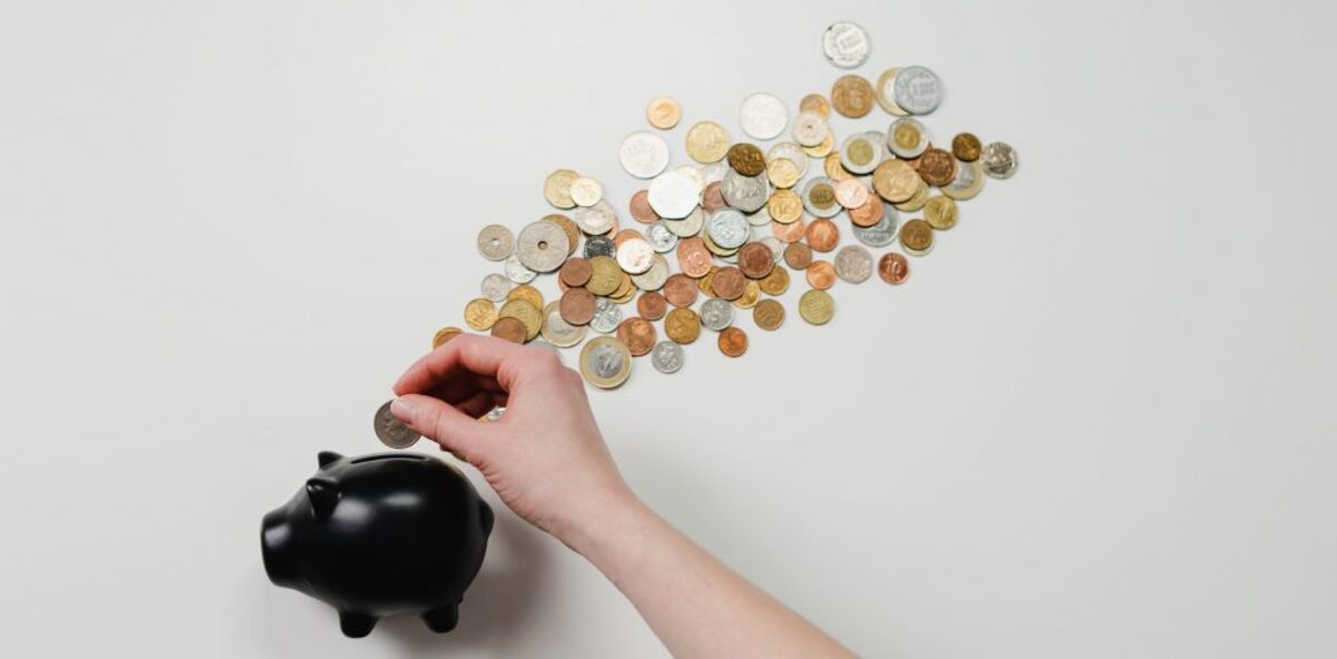 Person putting coin in a piggy bank