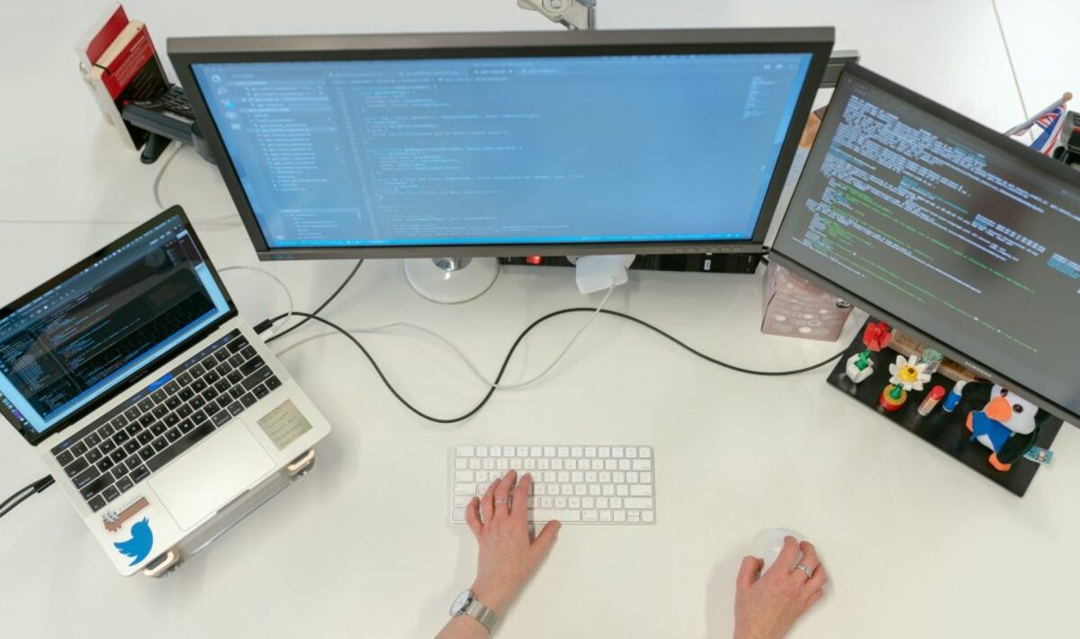 Female software engineer coding on computer