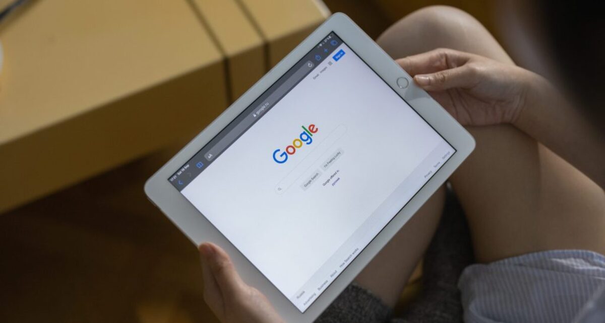 A person holding white ipad mini