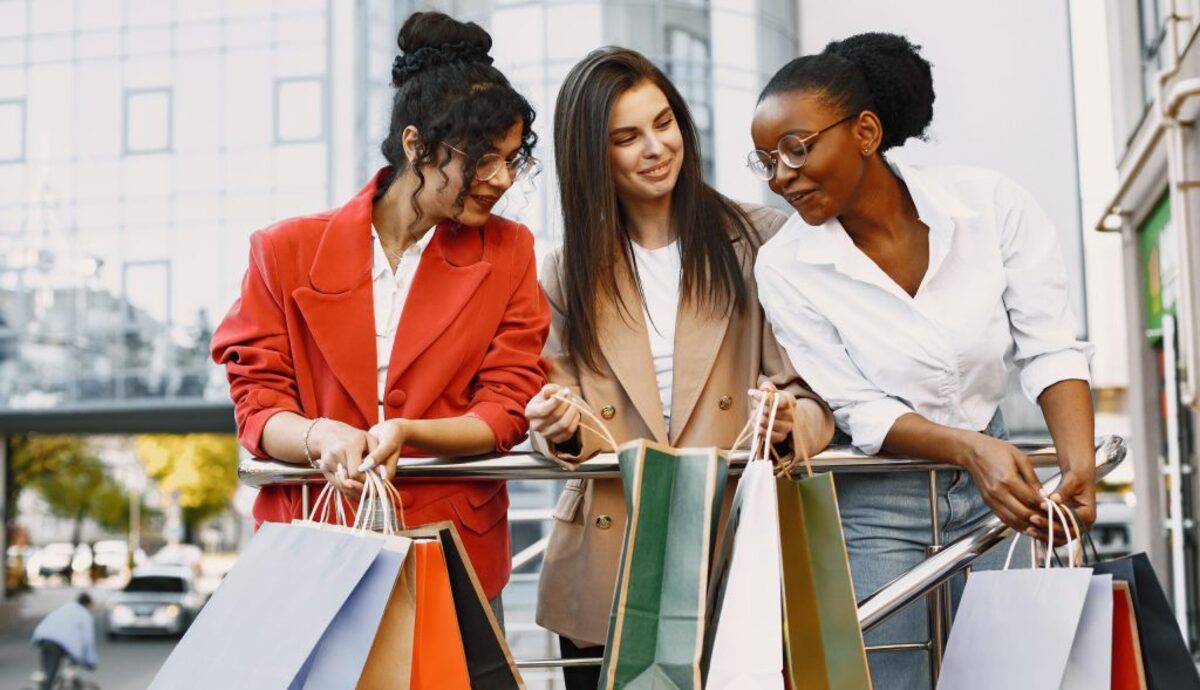 Happy female friends carrying shopping bags