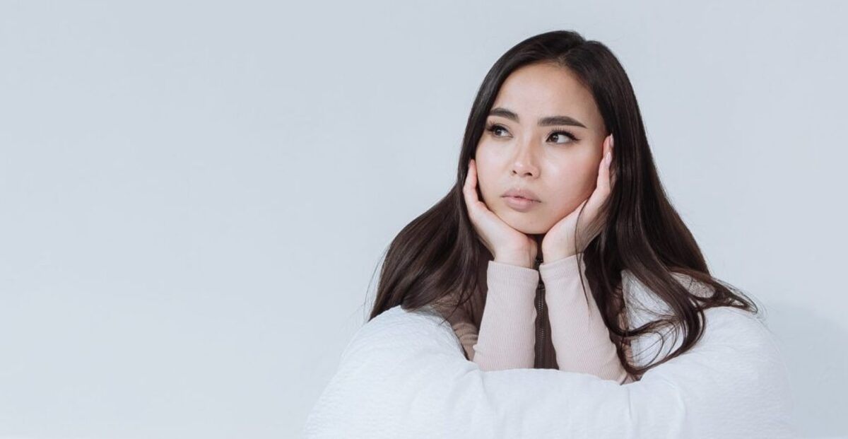 Pensive woman leaning on a white linen