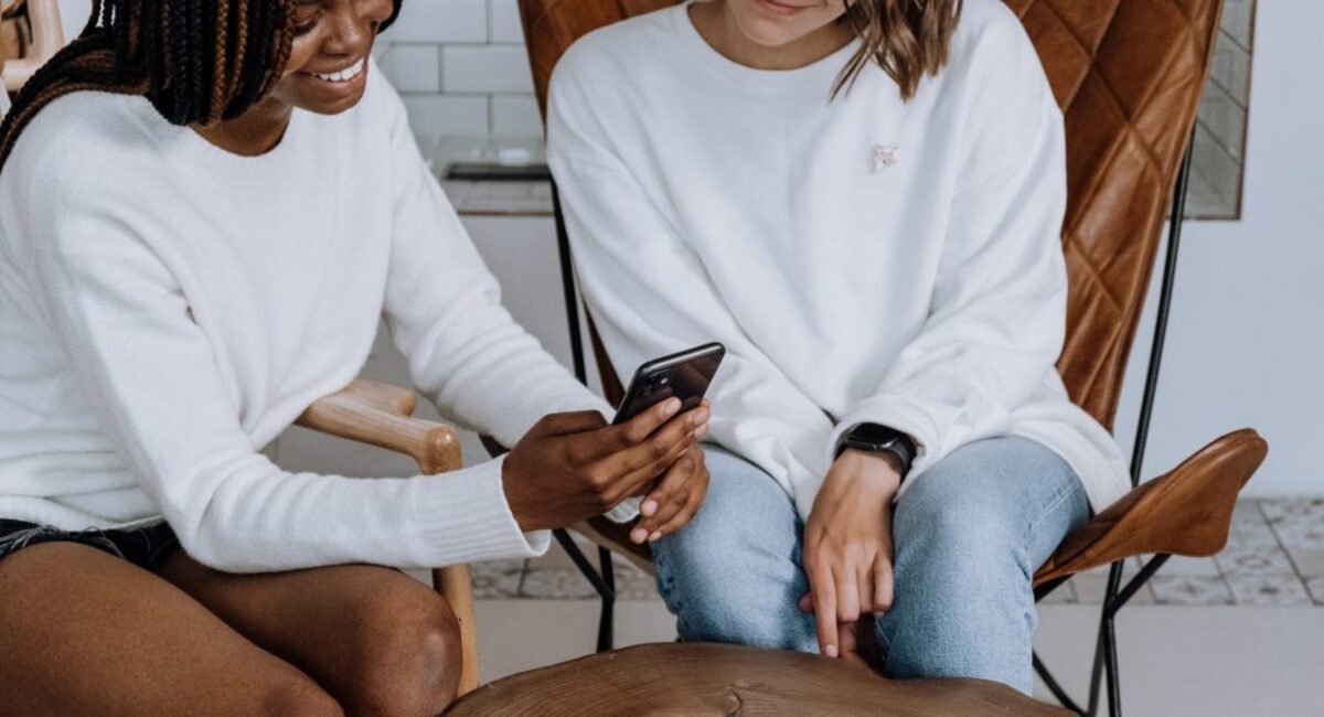 Woman in white long sleeve shirt and blue denim shorts sitting on chair