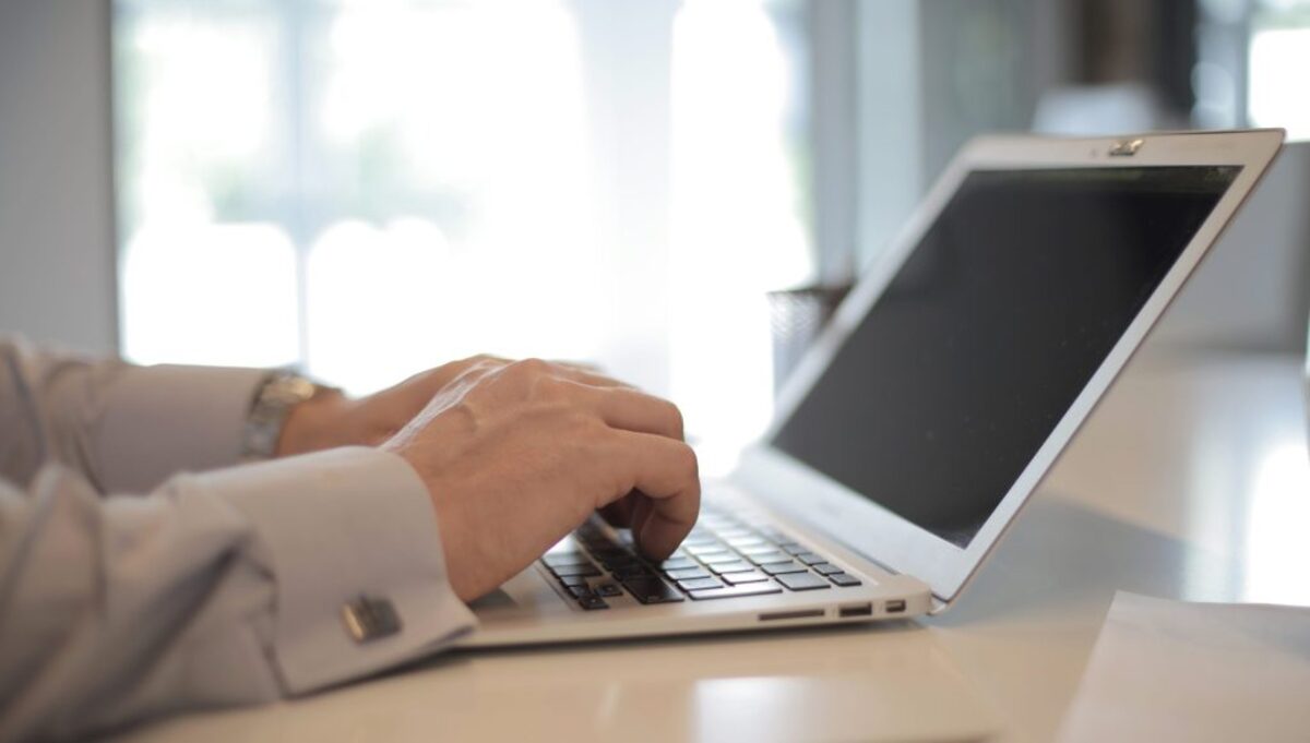 A man using laptop computer on white table